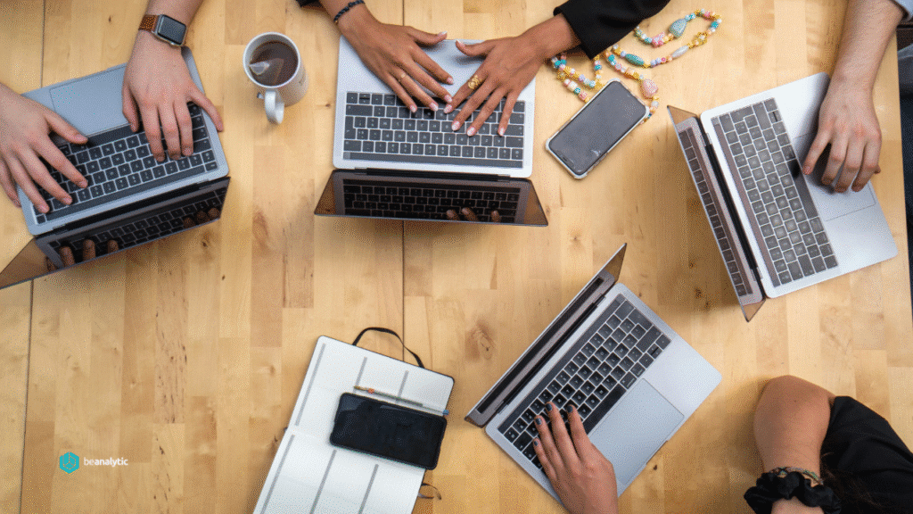 Equipe de especialistas em dados trabalhando em notebooks e telas com códigos e gráficos, simbolizando o processo técnico e estratégico envolvido na contratação de uma consultoria de dados.