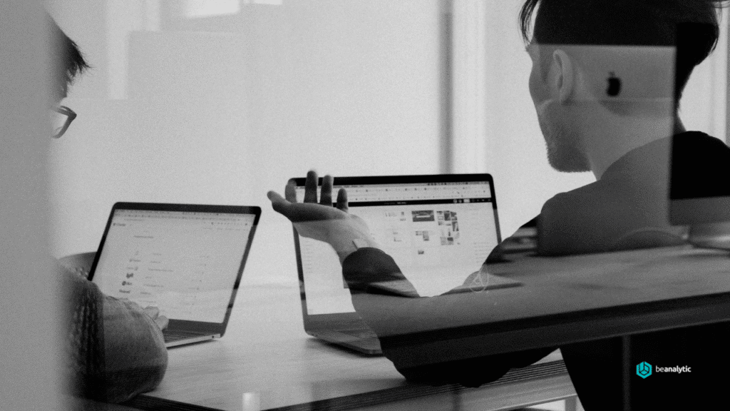 Dois profissionais trabalhando em ambientes diferentes — um representando uma consultoria de dados e outro um time interno — simbolizando a análise de performance e a busca pelo modelo que gera mais valor para o negócio. nuvem