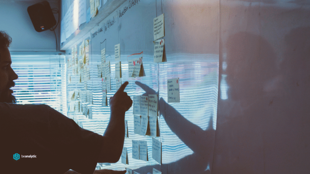 Profissionais de dados e executivos analisando painéis de Business Intelligence com gráficos e indicadores de desempenho em uma mesa de reunião moderna, representando as etapas de contratação e planejamento de uma consultoria de dados.