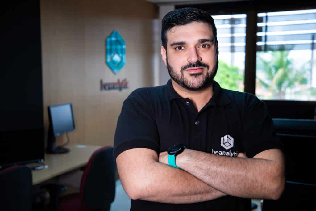 Profissional da beAnalytic no escritório, com o logotipo da empresa ao fundo