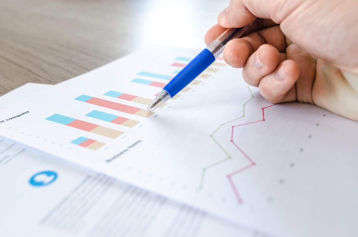 Executivo analisando gráficos de dashboard executivo em relatório impresso