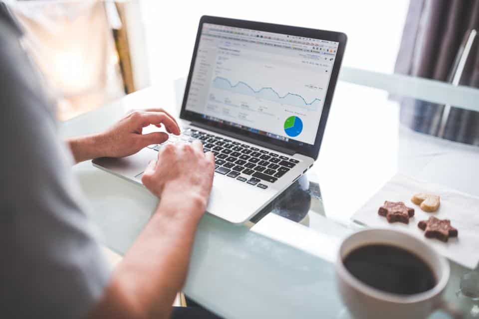 Profissional analisando gráficos de dados na tela do laptop, base para criar medidas em DAX