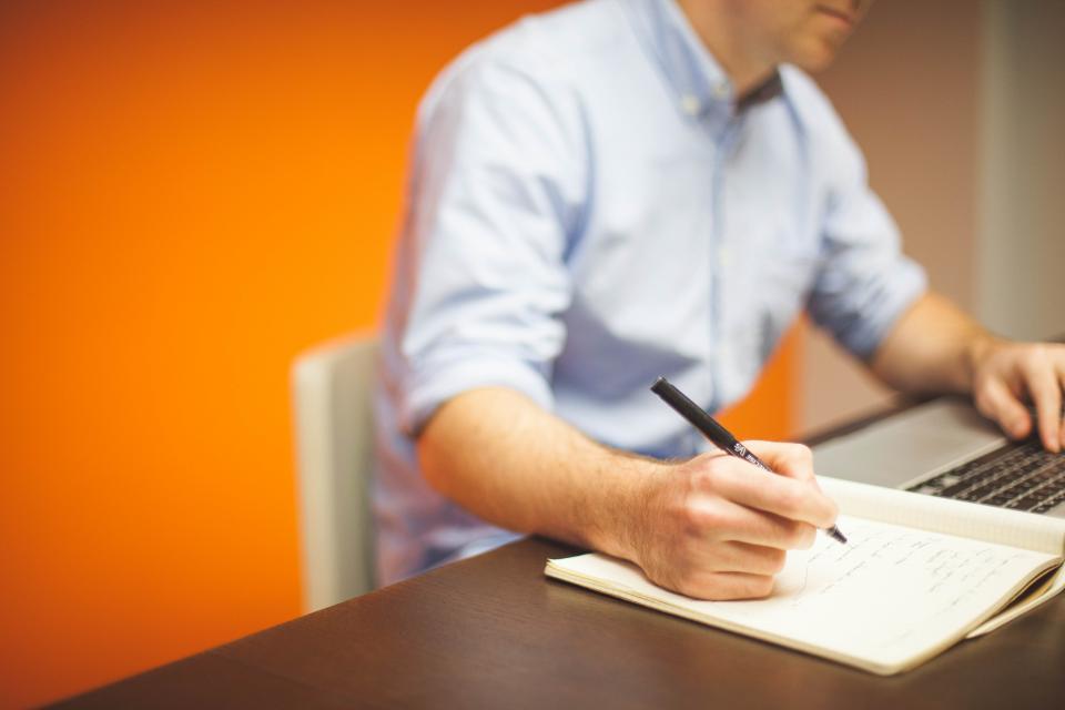 Profissional analisando e documentando definicoes de metricas de negocio
