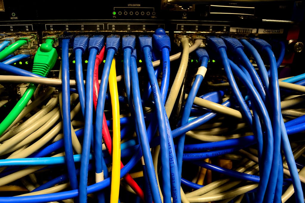 Cabos de rede organizados em rack de servidor, representando a infraestrutura por trás de pipelines de ETL e ELT