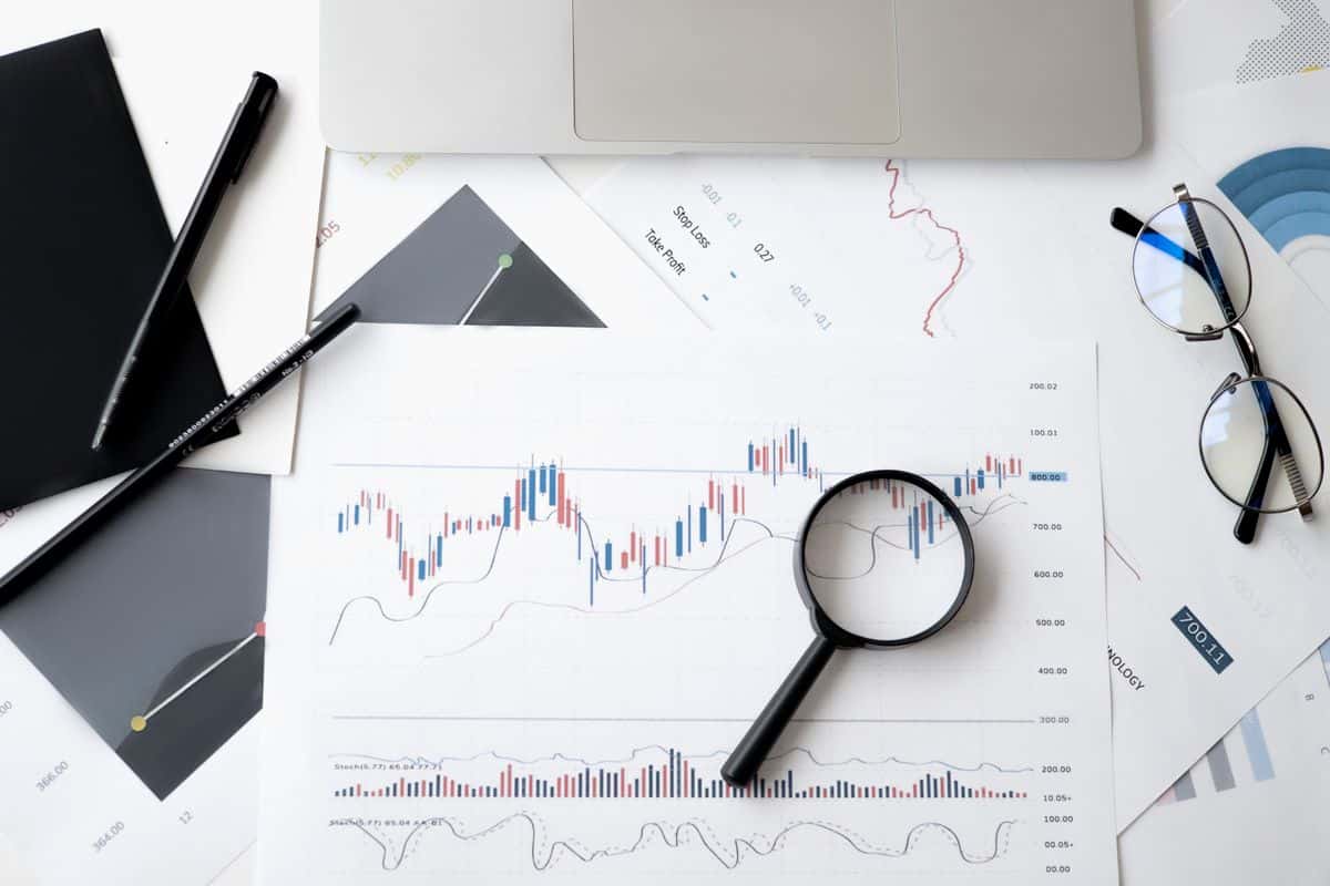 Lupa sobre gráfico de candlestick representando revisão de erros em dashboard