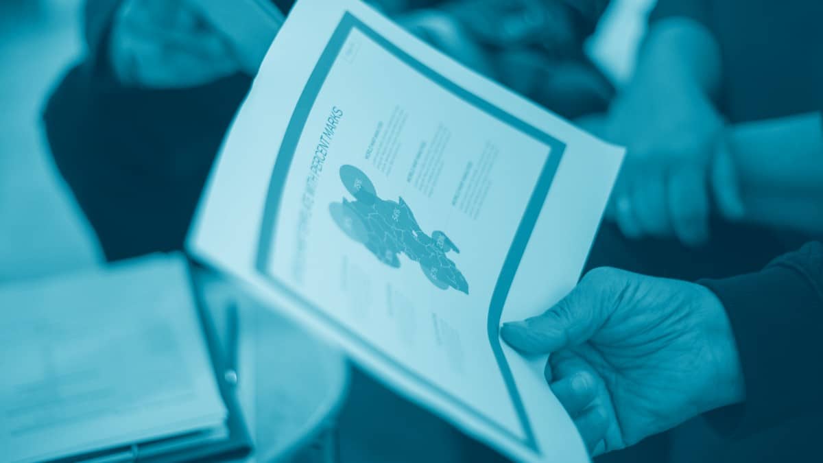 Equipe de liderança analisando dashboard de KPIs em reunião data-driven