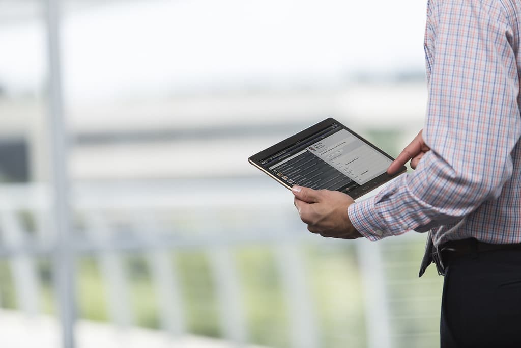 Profissional analisando dados em tablet, representando modelagem de dados aplicada à gestão