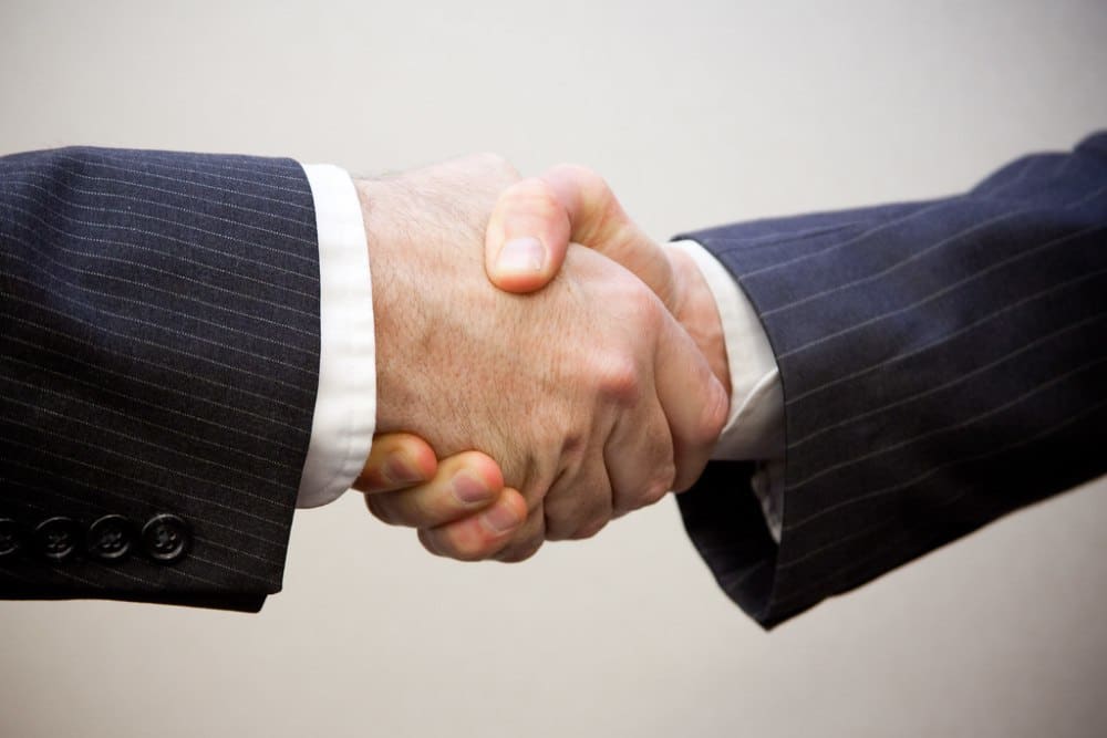 Aperto de mãos representando contrato de SLA em outsourcing de BI